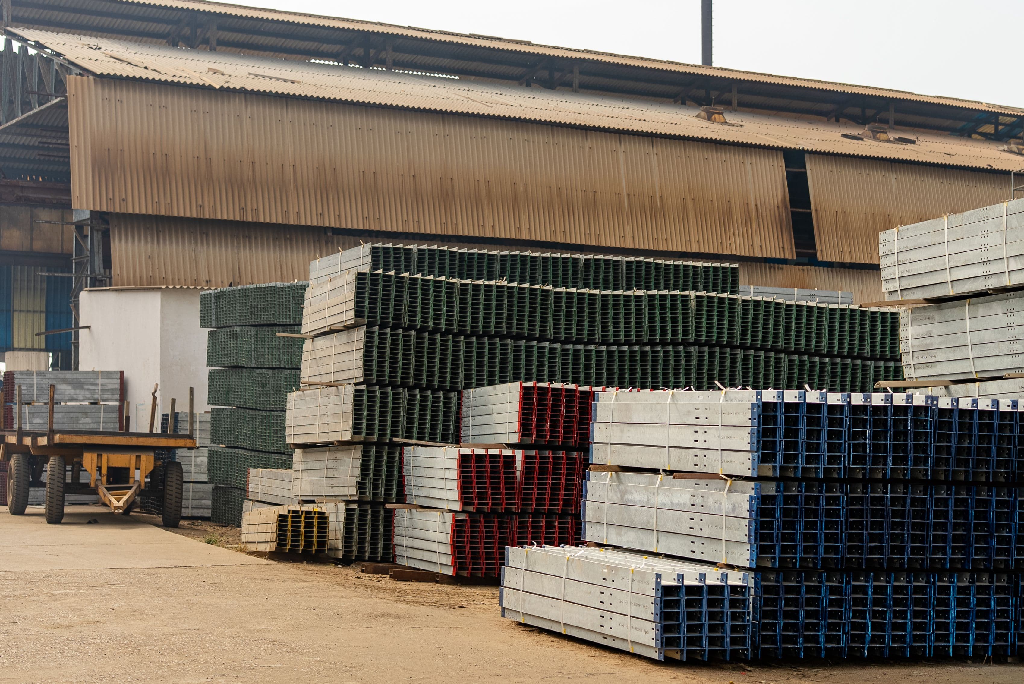 Industrial warehouse with stacked steel beams and pallets