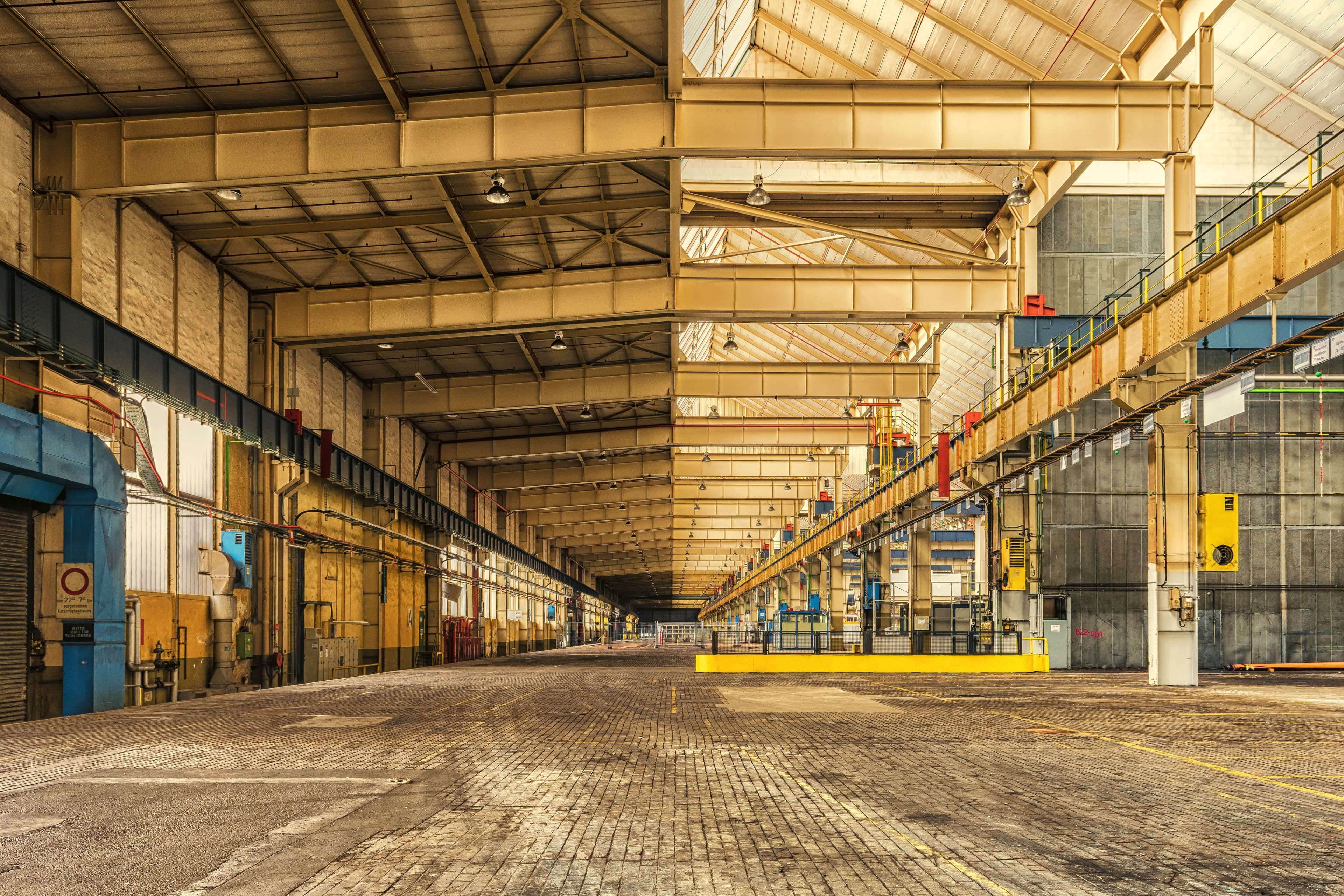 Expansive industrial steel plant hall with gantry crane rails