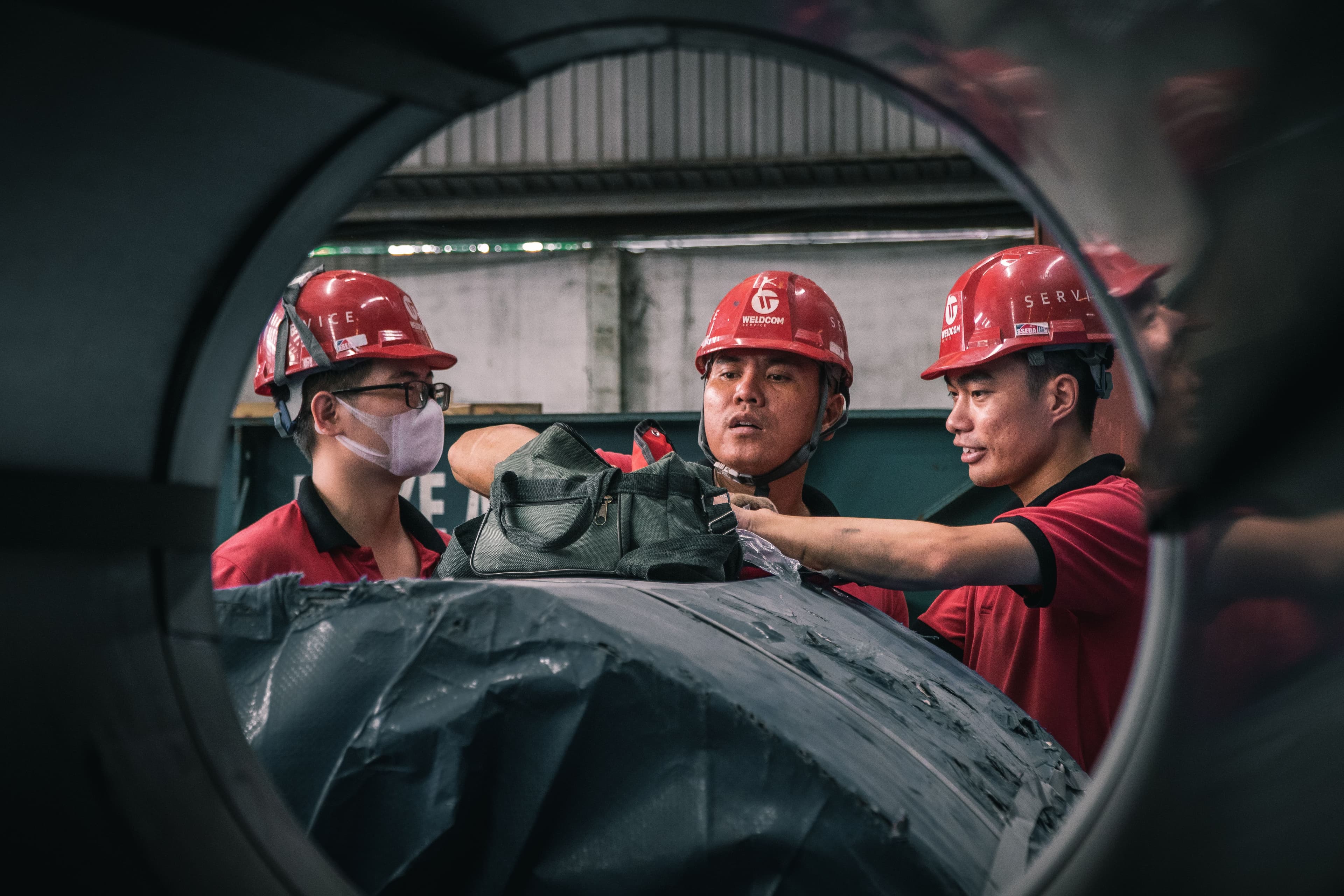 Team of workers in safety helmets collaborating in an industrial facility
