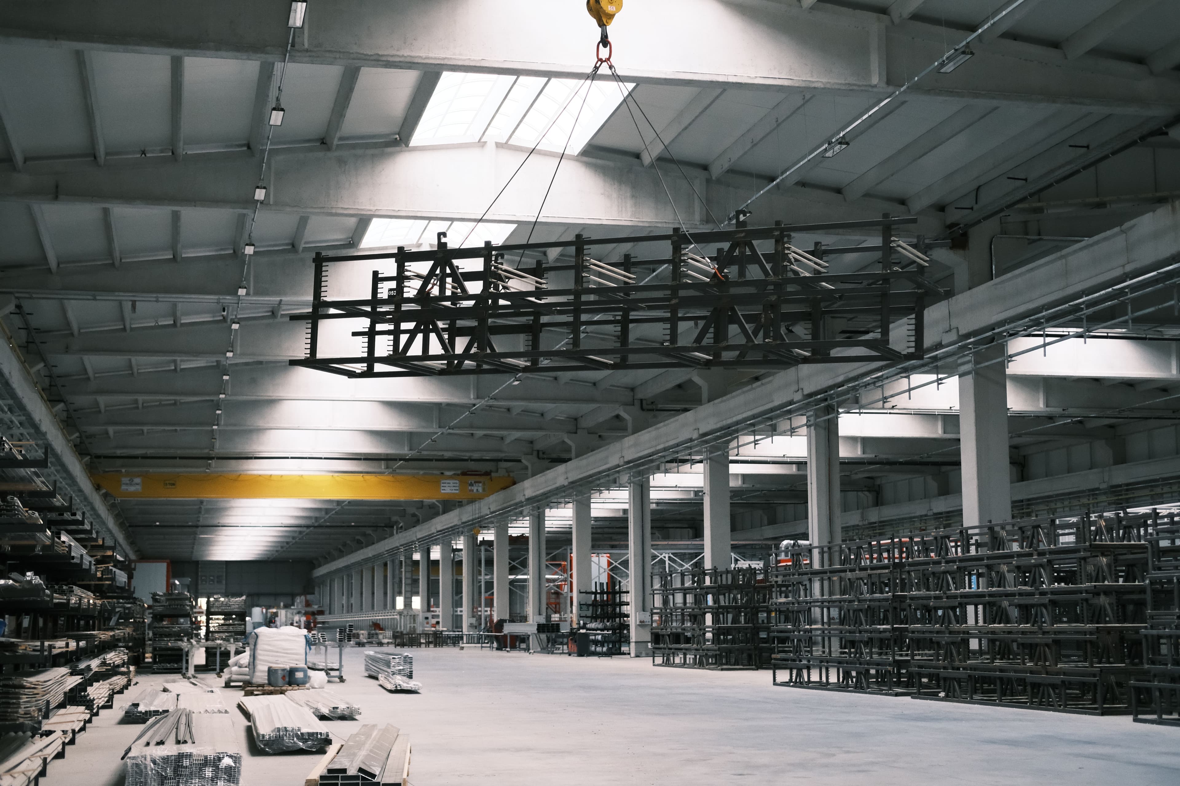 Industrial warehouse with an overhead crane lifting steel framework