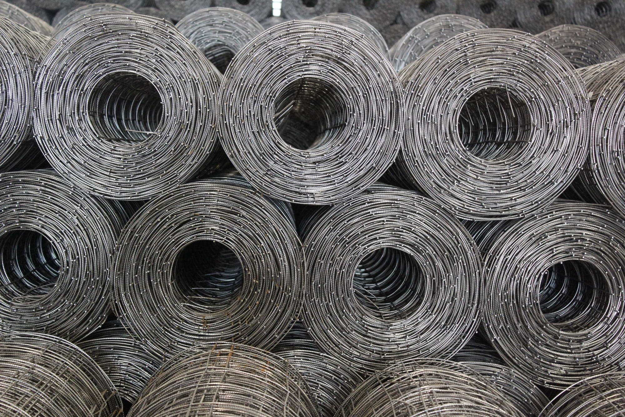 Coiled steel wire mesh rolls in a warehouse