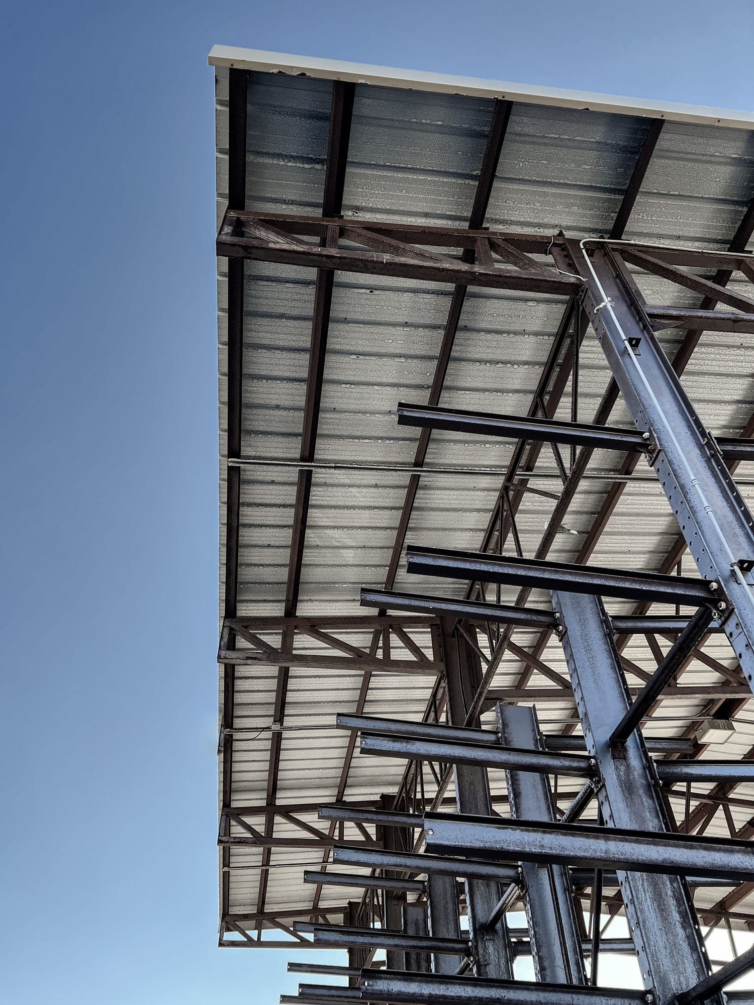 Industrial steel framework under construction against a clear sky