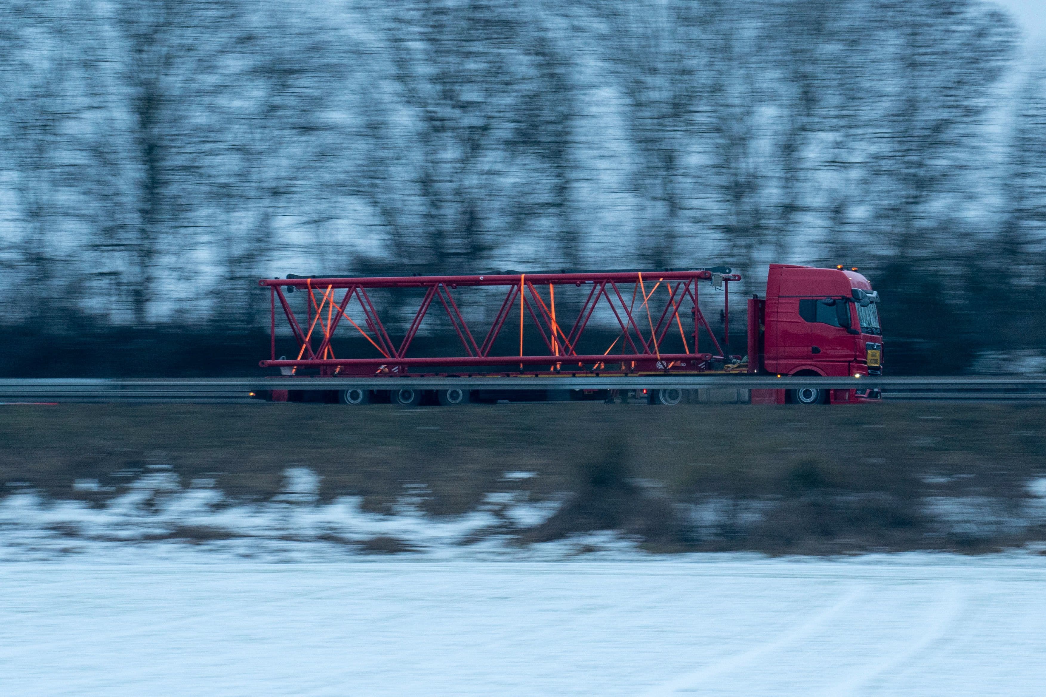Truck transporting a large steel beam on a highway